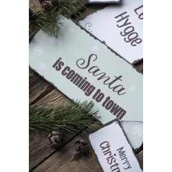 Metalskilt Santa is coming to town fra Ib Laursen liggende p� bord ved andre skilte - Tinashjem